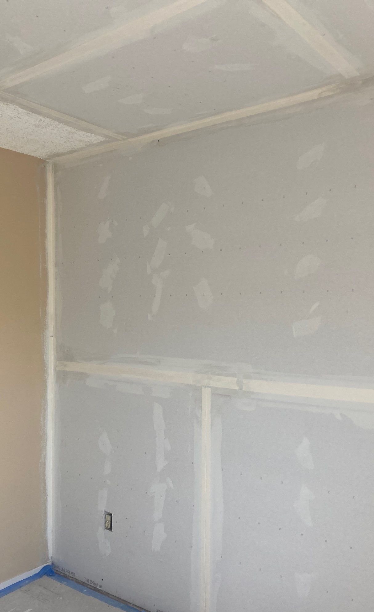 Drywall walls and ceiling being taped and finished before primer and paint
