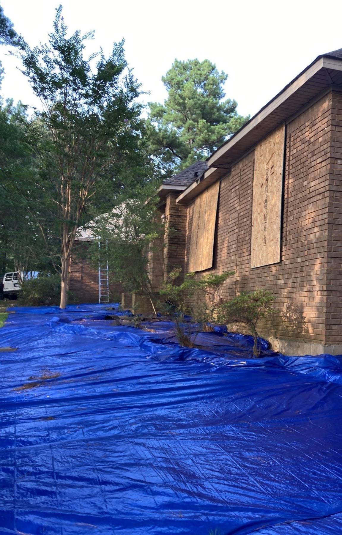 Window and door board-up with ground protection during fire damage restoration work