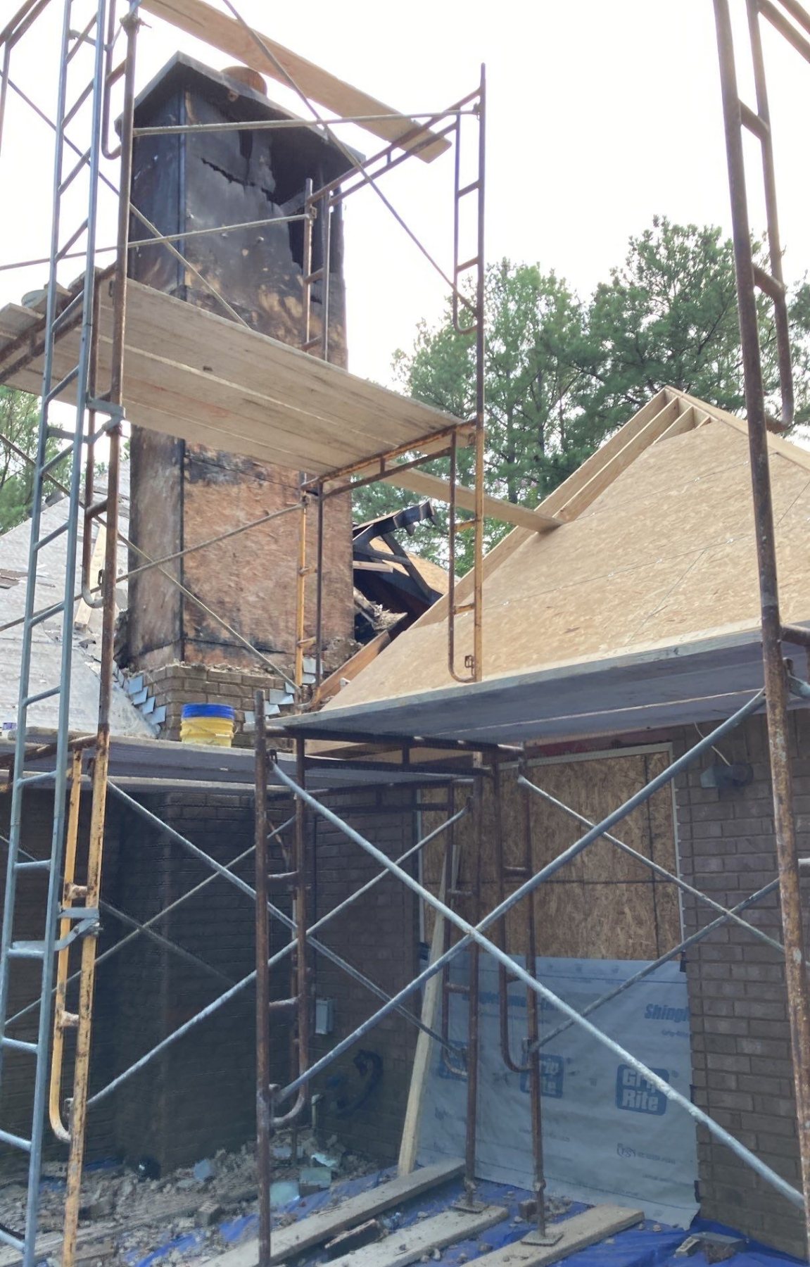 Fire-damaged chimney and roof during structural reconstruction