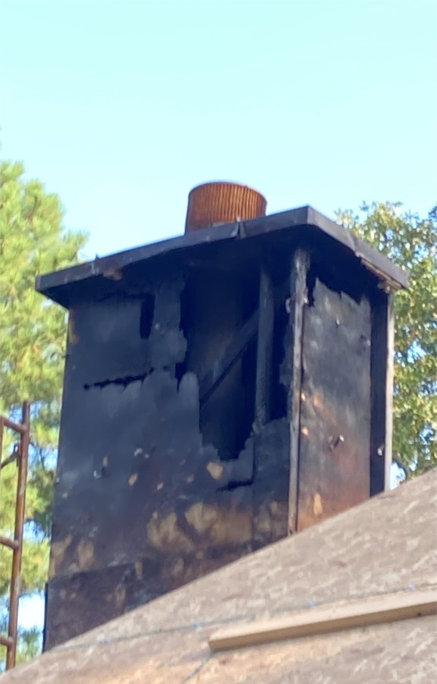 Fire damage to a chimney enclosure and adjoining roof structure