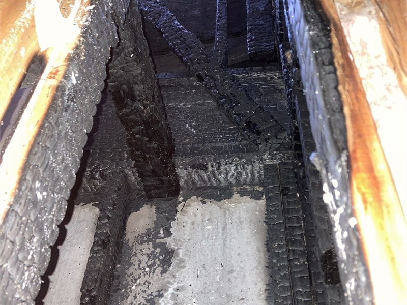 Charred structural framing exposed during inspection of concealed fire damage