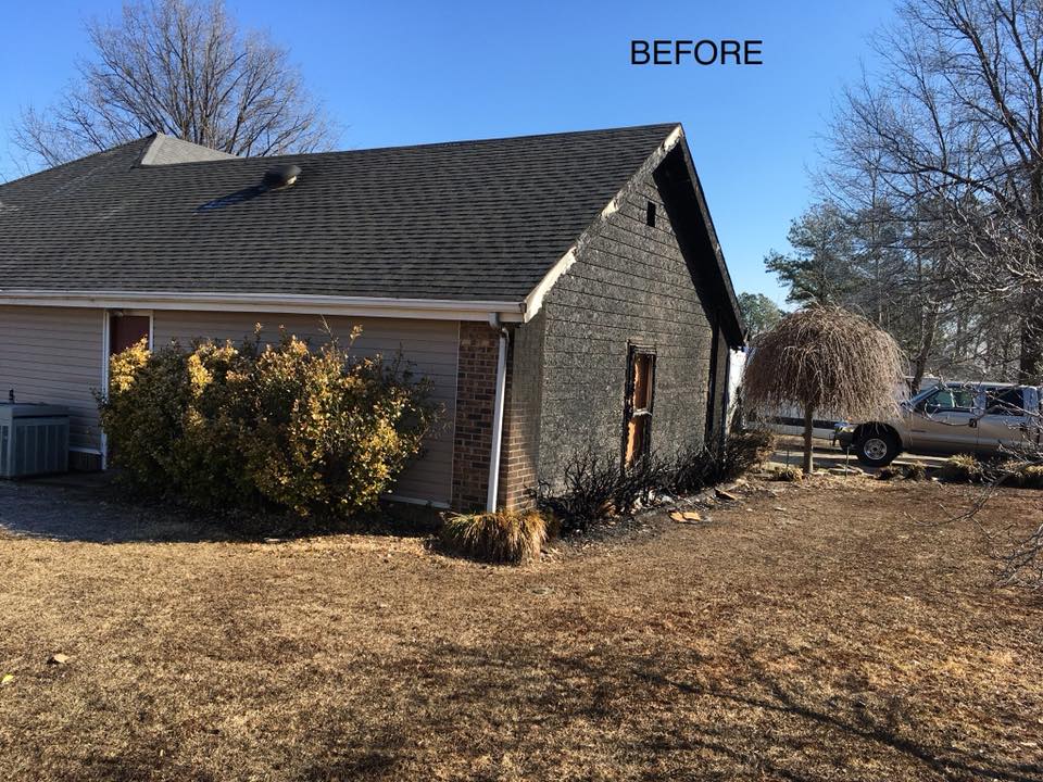 Fire-damaged exterior gable wall and window before restoration