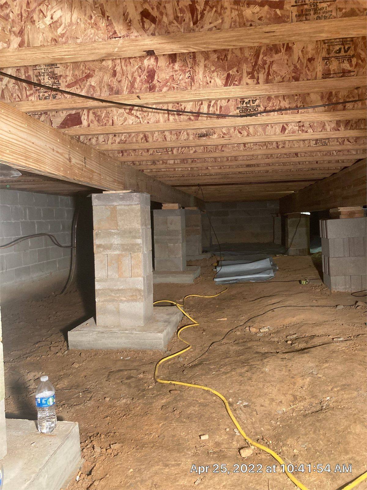 Completed concrete footing, masonry pier and girder installed beneath existing floor framing
