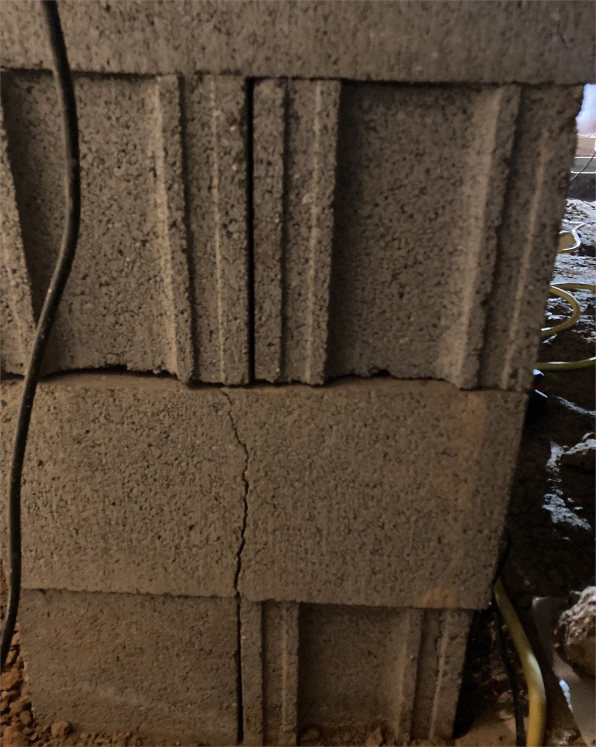 Damaged pier foundation support visible inside a crawlspace