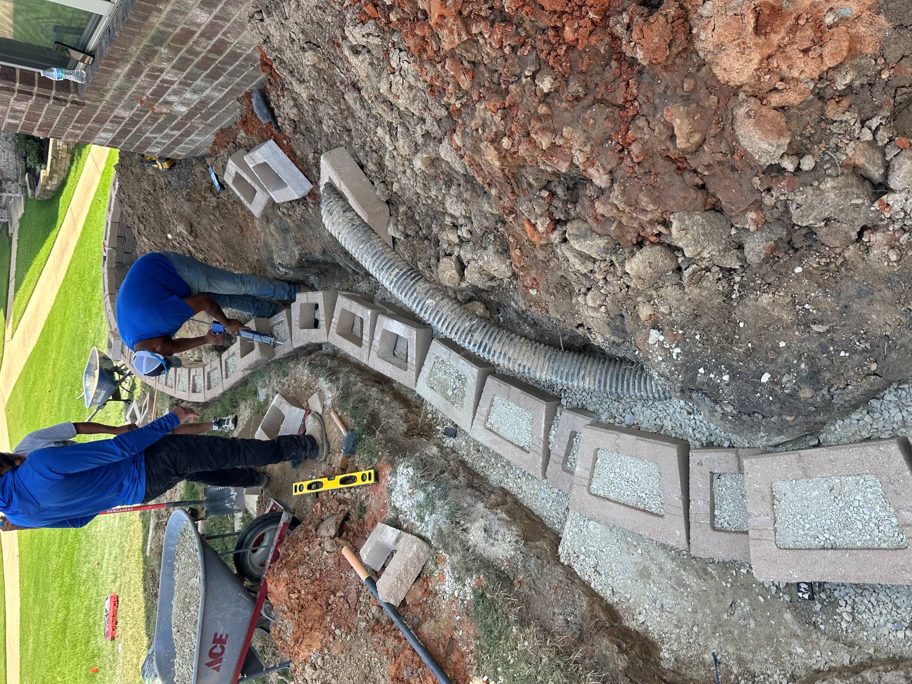 First retaining wall course being checked for alignment and elevation