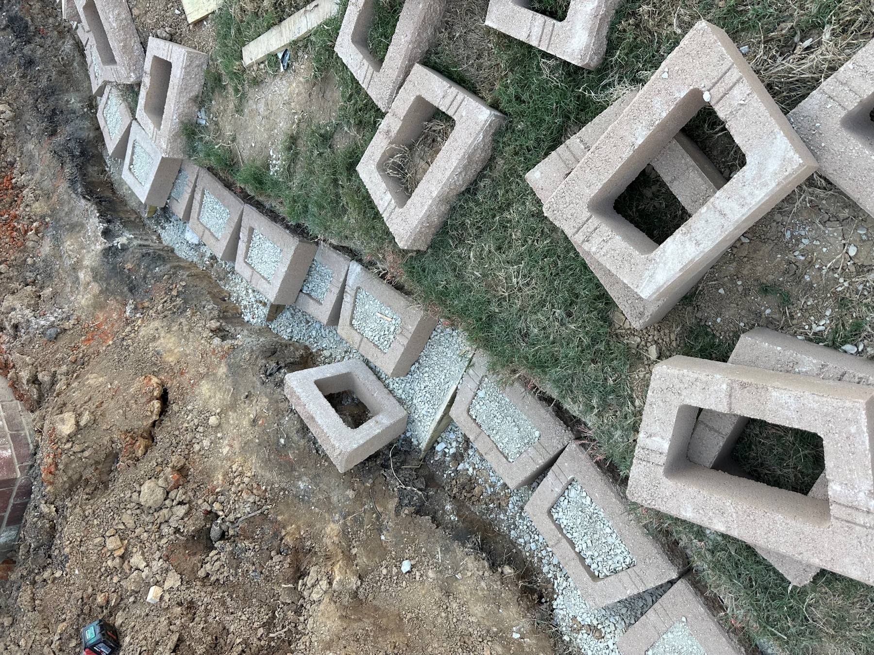 Initial retaining wall units positioned along a prepared curved aggregate base