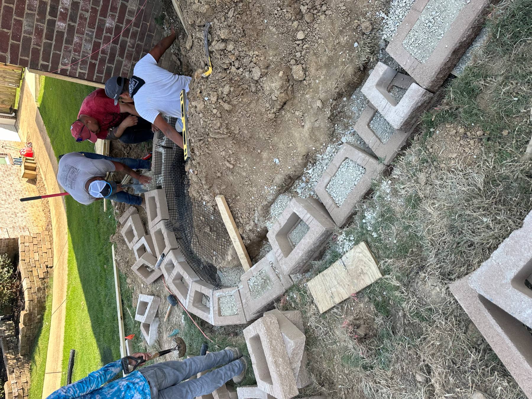 Curved retaining wall first course progressing along the planned route