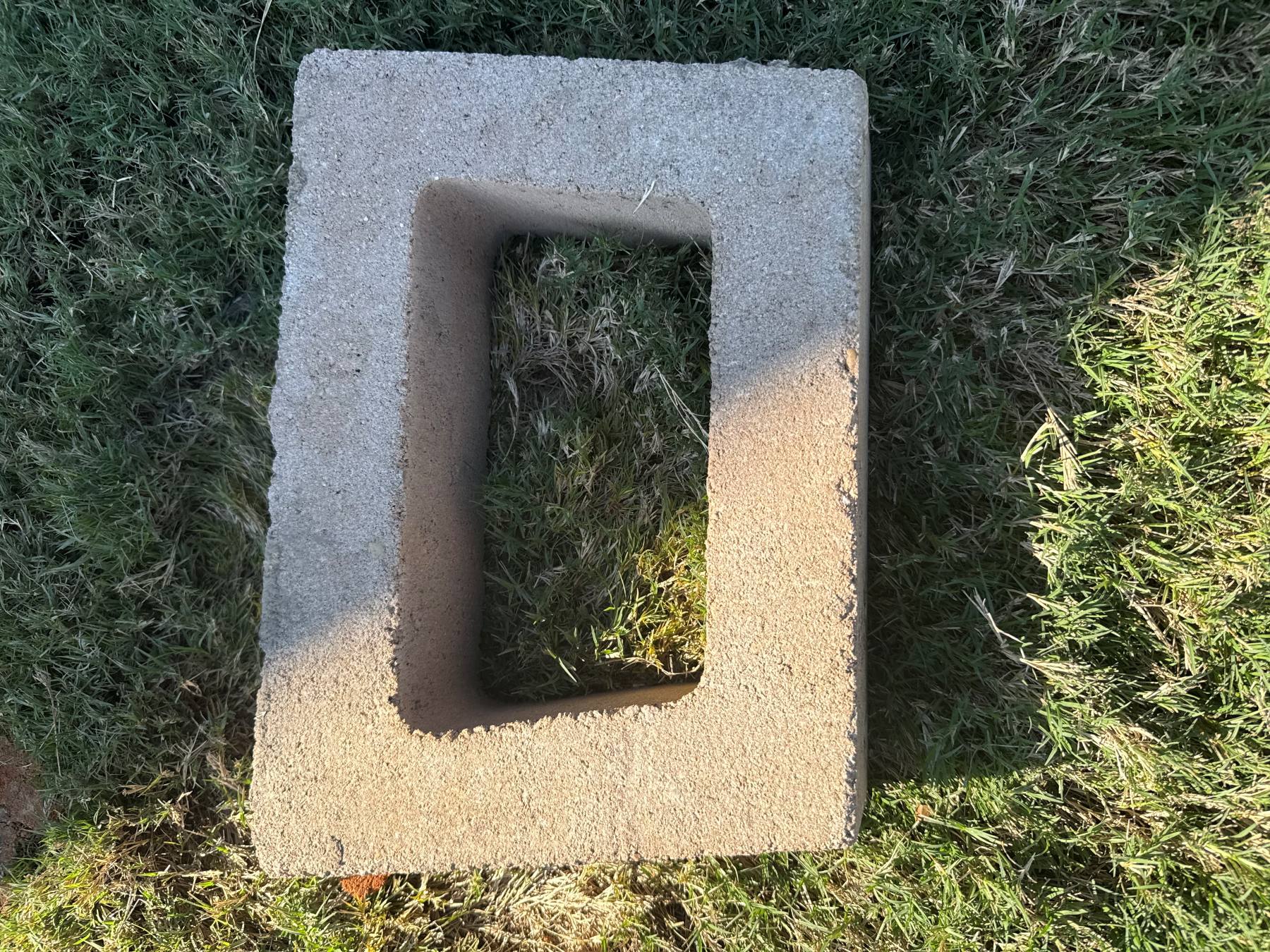 Hollow retaining wall unit viewed from above before installation and aggregate placement