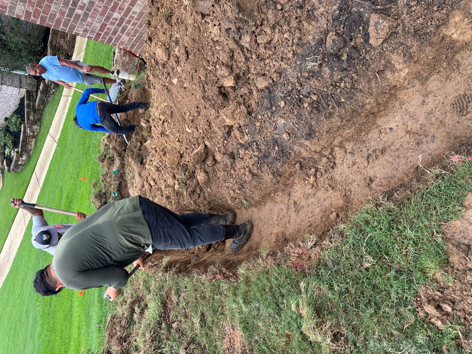 Initial excavation establishing a retaining wall route through an existing yard