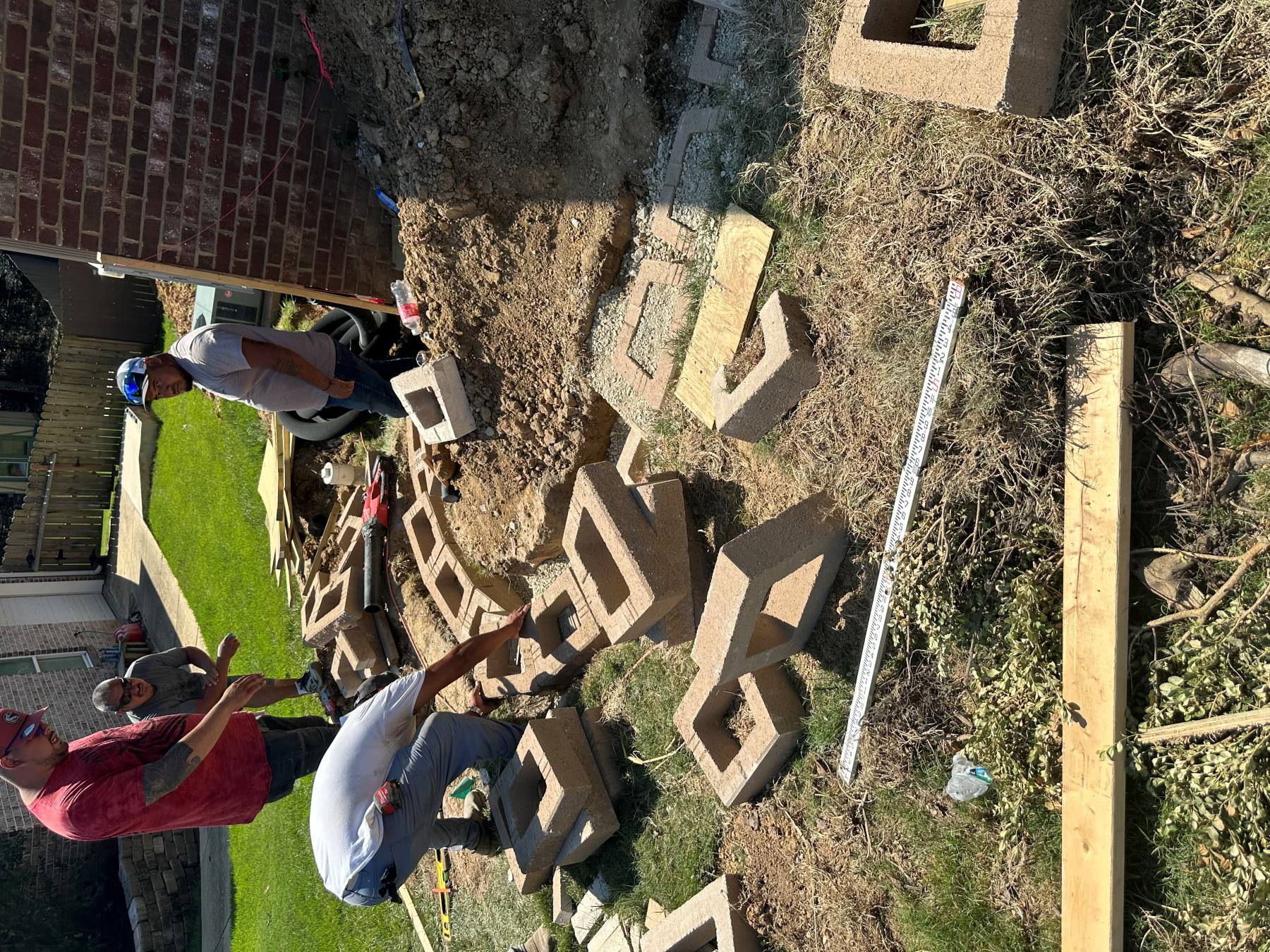 Active retaining wall unit placement with layout tools and staged construction materials
