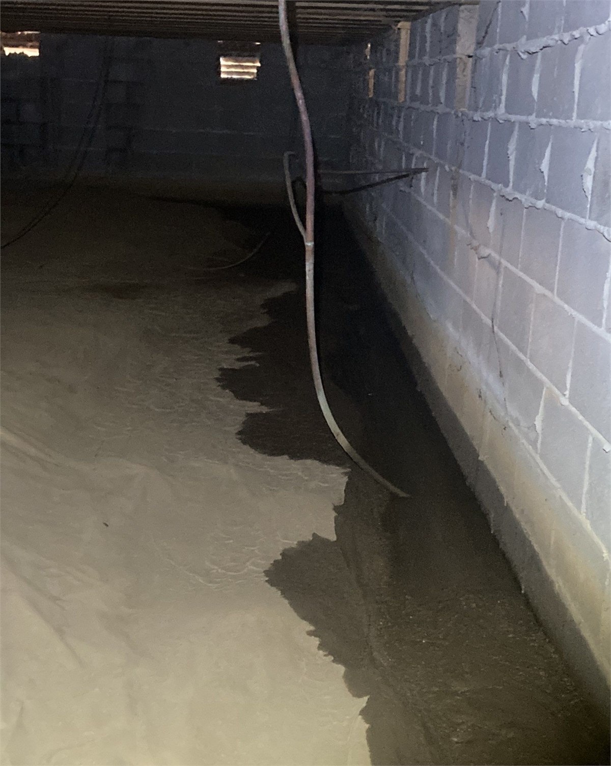 Water intrusion visible inside a crawlspace before moisture-control work