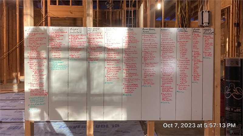 Room-by-room repair scope organized on a project planning board inside an exposed structure