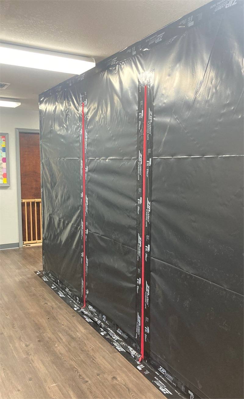 Full-height sealed containment barrier with controlled zipper entries separating the work area from the unaffected interior.
