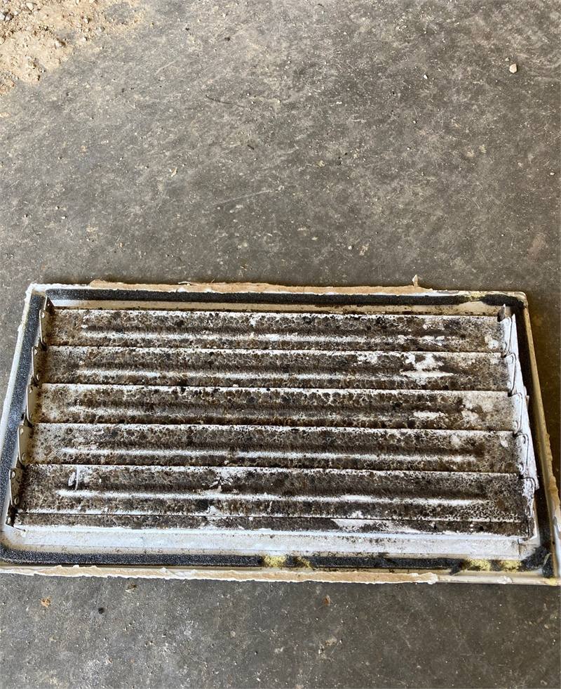 Removed HVAC air register with visible mold growth and accumulated debris documented during a building inspection.