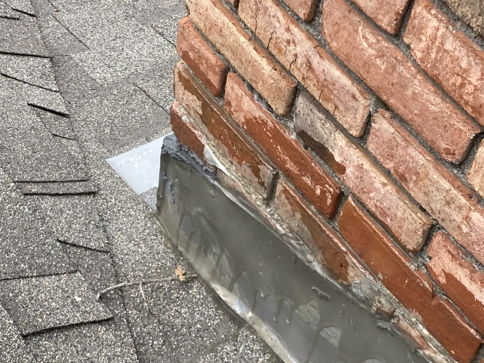 Failed roof flashing around a masonry chimney where water can enter the roof assembly.