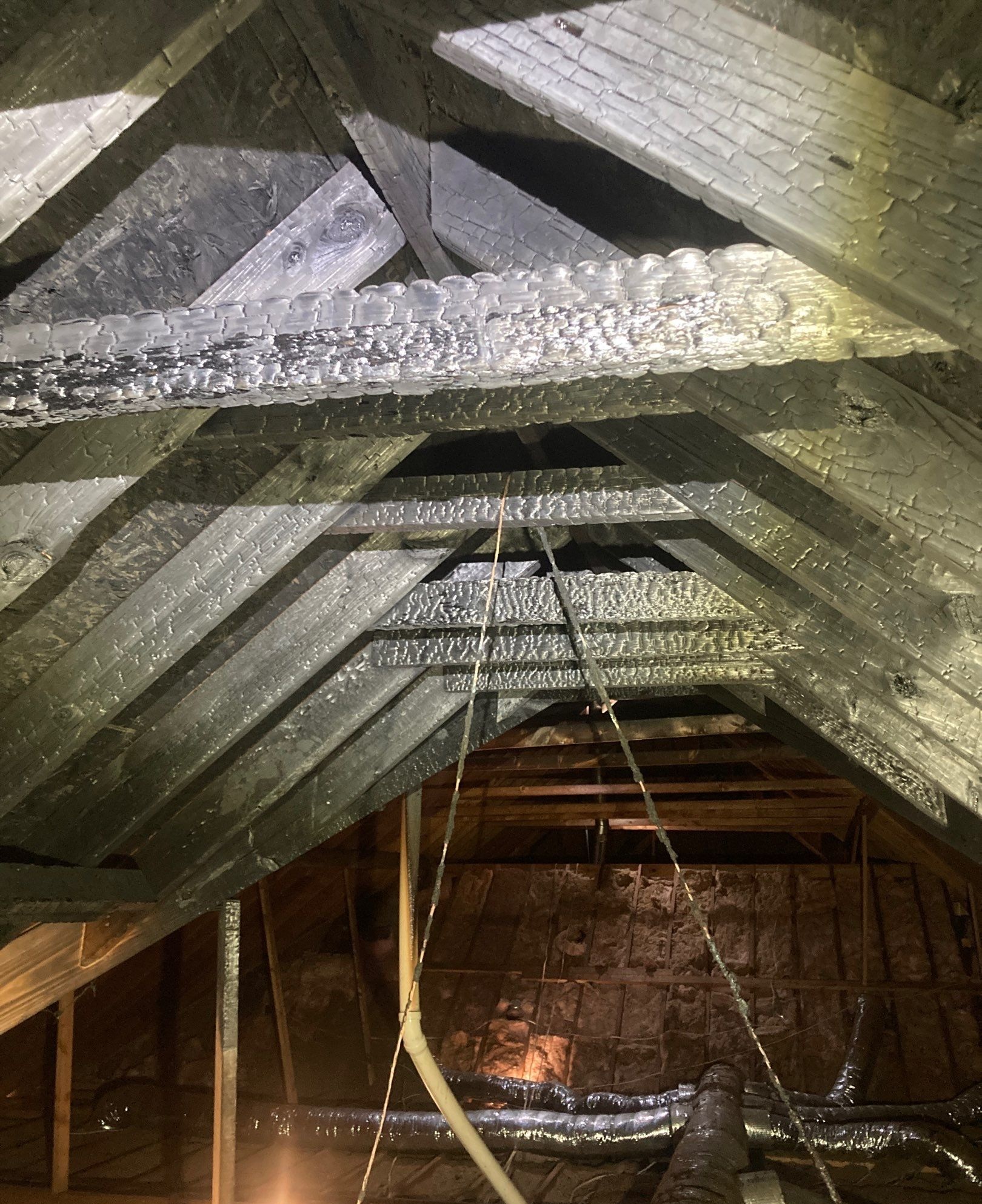 Fire damage affecting structural components within a roof system in Northeast Arkansas.