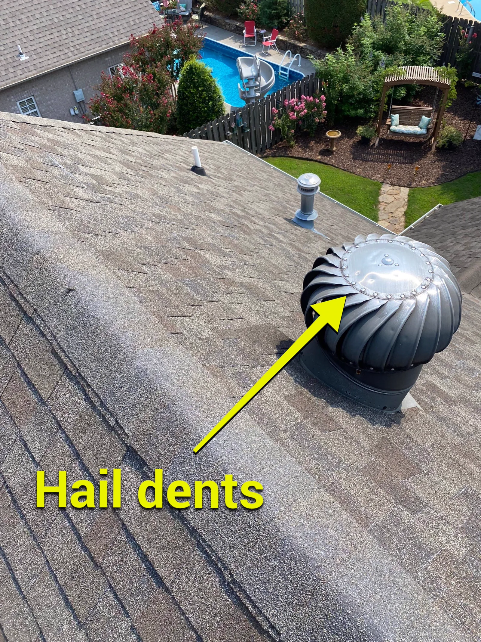 Hail damage visible on a roof exhaust vent during a roofing inspection.