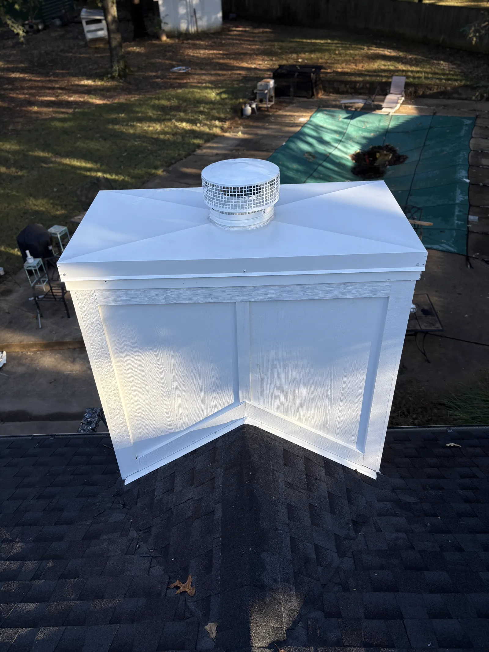 Roof repair work around a chimney and the surrounding flashing interface.